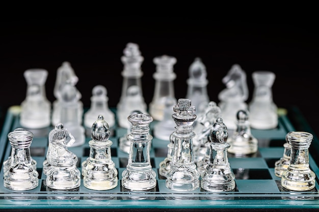 przezroczyste szachy z przezroczystego szkła na szachownicy selektywne skupienie zbliżenie odizolowane na czarno