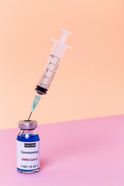 Przezroczyste szklane fiolki z testową szczepionką COVID-19, ze strzykawkami. Wybrany cel.