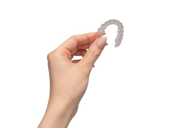 Zdjęcie przezroczysty ochraniacz na zęby w kobiecej dłoni odizolowany na białym tle