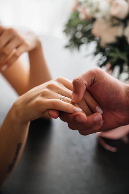 Przycięta para trzymająca się za ręce na stole