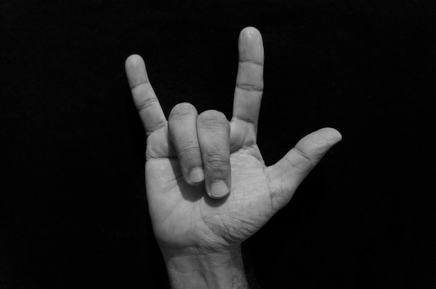Zdjęcie przycięta ręka człowieka gestując na czarnym tle
