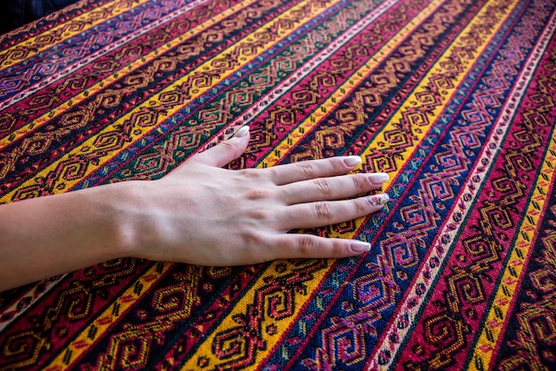 Zdjęcie przycięta ręka kobiety dotykającej tkaniny z wzorem