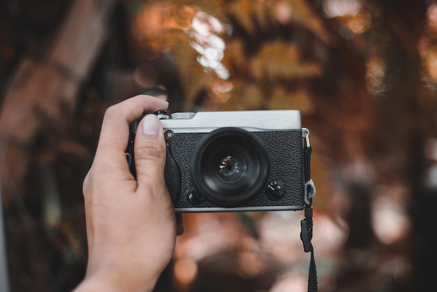 Przycięta ręka kobiety fotografującej z kamerą na świeżym powietrzu