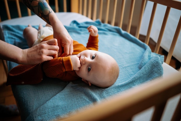 Przycięta ręka matki noszącej ubrania dla dziecka