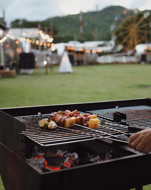 Przycięta ręka osoby przygotowującej jedzenie na grillu