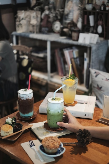 Przycięta ręka osoby trzymającej drinka na stole