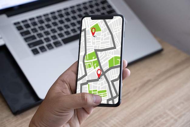 Przycięta ręka osoby używającej mapy na telefonie komórkowym