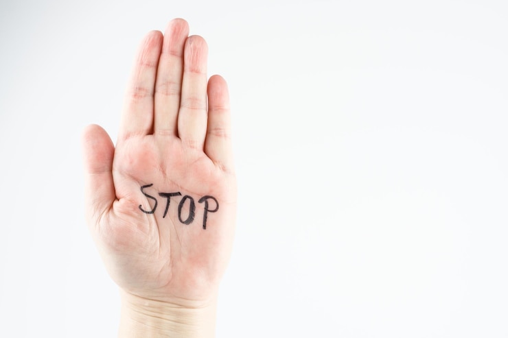 Zdjęcie przycięta ręka z tekstem stop na białym tle