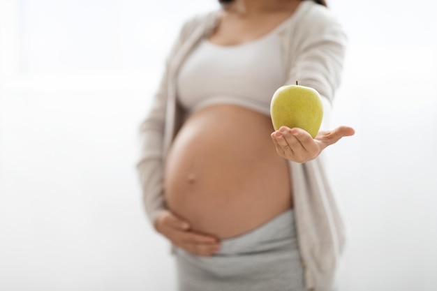 Przycięte Kobiety W Ciąży Trzymającej Zielone Jabłko Na Białym