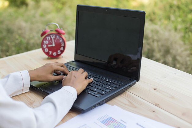 Zdjęcie przycięte ręce osoby używającej laptopa na stole