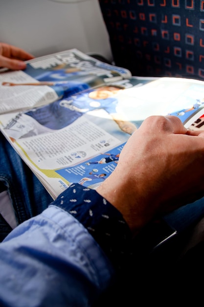 Zdjęcie przycięte ręce trzymające książkę w samolocie