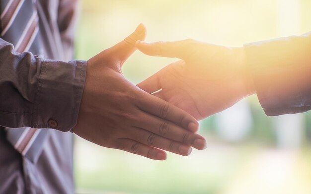 Zdjęcie przycięte ręce współpracowników uściskających sobie ręce