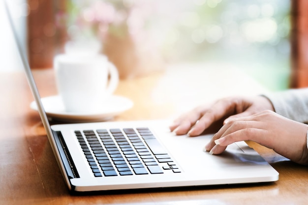 Przycięte ręce za pomocą laptopa na stole