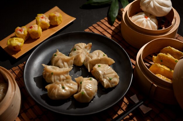 Przycięte strzał z talerza i parowiec bambusa z pierogi Dimsum w chińskiej restauracji