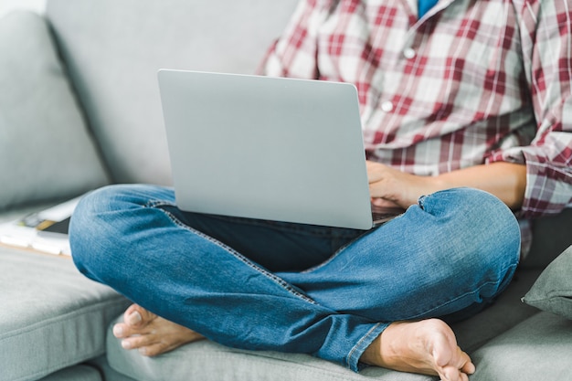 Przycięte zbliżenie dłoni biznesmena pisania pracy na laptopie w domowym biurze. Freelancer, zawód zdalny, korepetytor, koncepcja e-learningu dla studentów