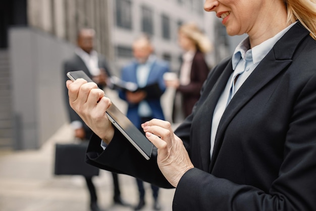 Zdjęcie przycięte zdjęcie rąk bizneswoman stojącej i korzystającej z tabletu