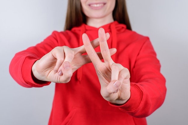 Zdjęcie przycięte zdjęcie z bliska portret pozytywnego uroczego całkiem pięknego nastolatka nastolatka człowieka daje sygnał hashtag na białym tle szarym tle