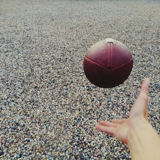 Zdjęcie przycięty obraz osoby grającej w piłkę nożną na plaży