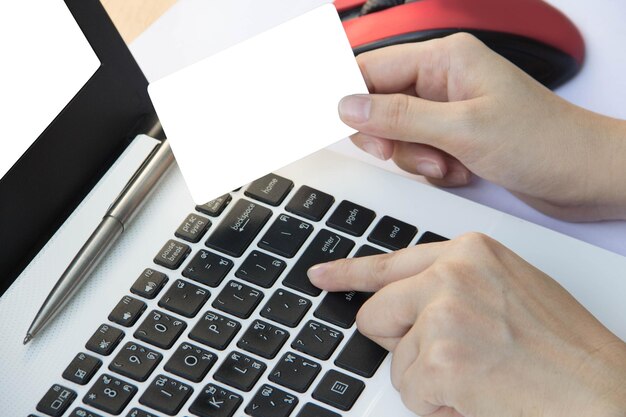 Zdjęcie przycięty obraz osoby trzymającej wizytówkę podczas korzystania z laptopa