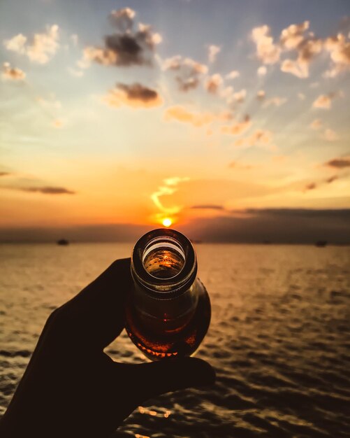 Przycięty obraz piwa na tle nieba podczas zachodu słońca