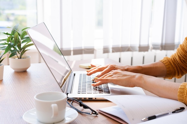 Przycięty obraz profesjonalna biznesowa kobieta pracująca w swoim biurze za pośrednictwem laptopa
