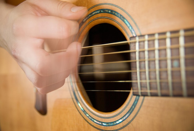 Przycięty obraz ręki grającej na gitarze