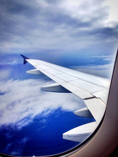 Zdjęcie przycięty obraz samolotu na tle nieba widziany przez okno
