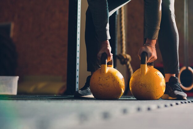 Przycięty Strzał Sportowca Robi ćwiczenia Z Czajnikiem Dzwon. Sprzęt Do Podnoszenia Ciężarów, Podnoszenia Ciężarów I Cross-fit. Sport, Fitness Koncepcja.