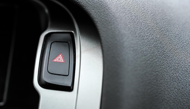 Przycisk trójkąta czerwonego światła ostrzegawczego w nowoczesnym panelu wnętrza samochodu, szczegóły zbliżenia