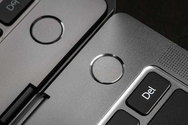 przyciski klawiatury i fragmenty laptopa w czarno-srebrnym tle