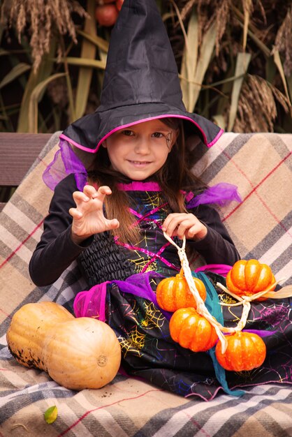 Przygotowania do Halloween Dziewczyna przebrana za złą wiedźmę w sukience i wielkim kapeluszu Jest w dobrym nastroju