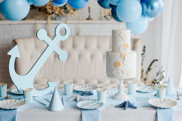 Przygotowany stolik urodzinowy z papierową elegancką zastawą stołową na przyjęcie dla dzieci w niebieskich kolorach. Dzień baby shower, koncepcja morze