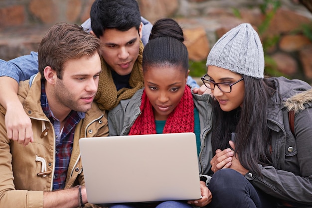 Przyjaciele I Partnerzy Studiów Ujęcie Grupy Studentów Korzystających Z Laptopa Siedzących Na Terenie Kampusu