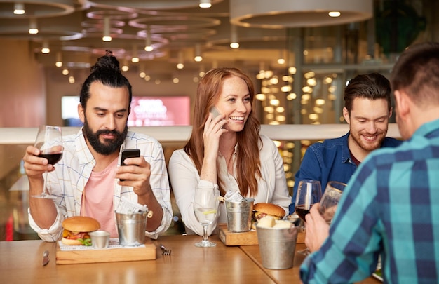 Przyjaciele jedzą i piją wino w restauracji.