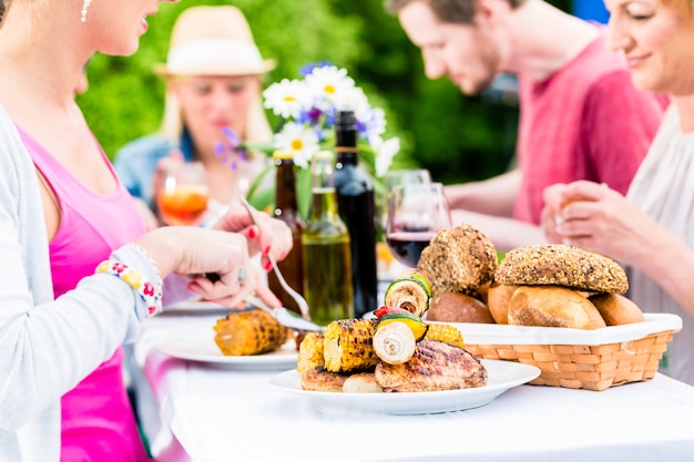 Przyjaciele Jedzą Kiełbasę Z Grilla I Mięso W Ogrodzie Lub Na Grillu