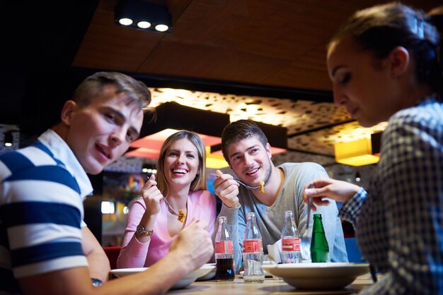 przyjaciele mają przerwę w centrum handlowym, jedząc włoskie fast foody