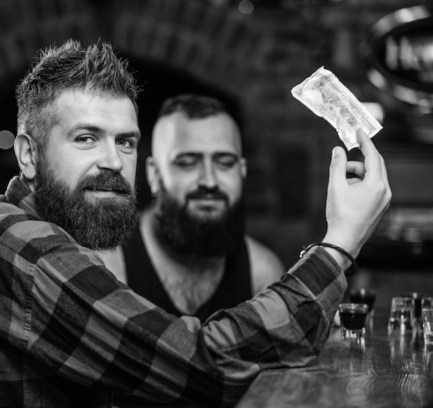 Zdjęcie przyjaciele odpoczywają w pubie hipster brutalny brodaty mężczyzna spędzają wolny czas z przyjacielem przy barze zamów drinki przy barze mężczyźni odpoczywają przy barze przyjaźń i wypoczynek piątkowy relaks w barze
