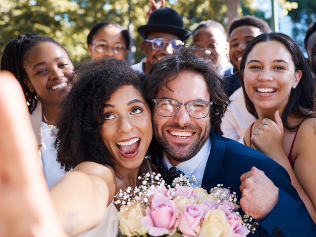 Przyjaciele panna młoda i pan młody z selfie weselnym na ceremonię plenerową świętowanie szczęścia, miłości i radości Małżeństwo szczęśliwe i międzyrasowe zdjęcie związku razem z podekscytowanymi gośćmi