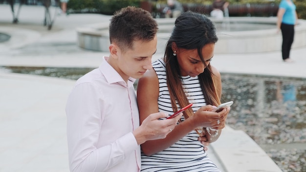 Przyjaciele patrzą na kamerę, stojąc na telefonie komórkowym