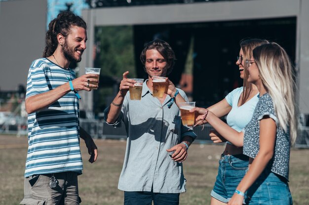 Przyjaciele piją piwo i bawią się na festiwalu muzycznym