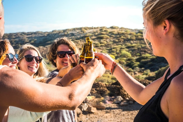 Zdjęcie przyjaciele pijący butelki piwa stojący na tle nieba
