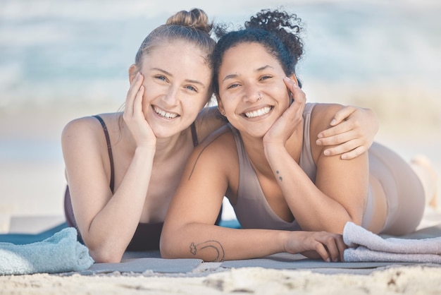 Przyjaciele plaża i różnorodność z czarną kobietą i szczęśliwą przyjaciółką leżącą na piasku nad morzem lub oceanem w naturze Twarz uśmiech i lato z kobietą i przyjaciółką nad wodą, aby zrelaksować się na wakacjach