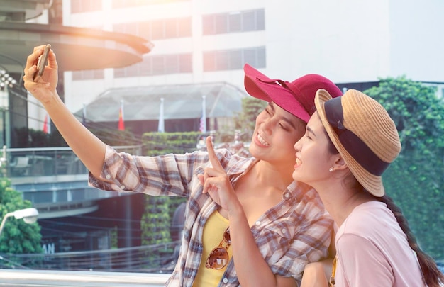 Zdjęcie przyjaciele robią sobie selfie przez telefon komórkowy w mieście.
