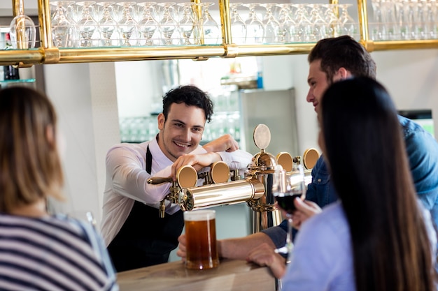 Przyjaciele rozmawiają z barmanem podczas drinków