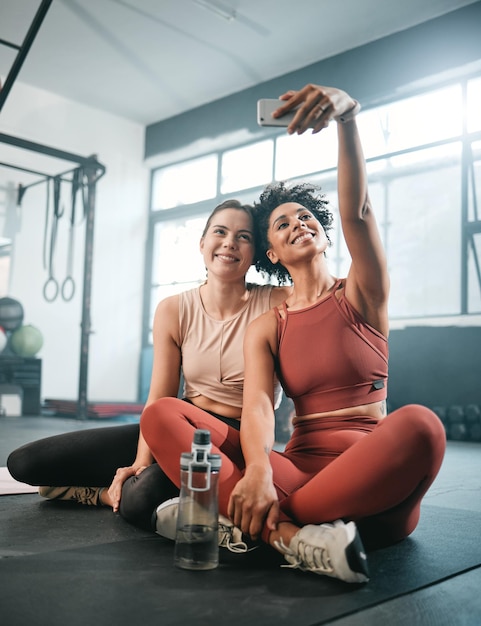Przyjaciele selfie i fitness z kobietami na siłowni do treningu w mediach społecznościowych i blogu odnowy biologicznej Trening ćwiczeń i zdrowie z dziewczyną sportowcem i telefonem do publikowania online i zdjęć sportowych