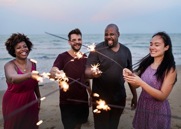 Przyjaciele świętuje Z Sparklers Na Plaży