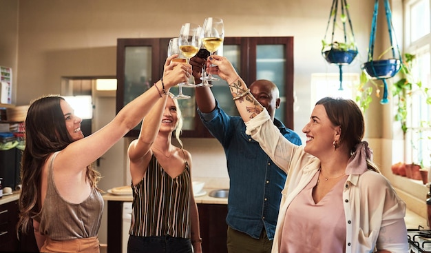 Przyjaciele winiarzy i toasty w kuchni na uroczystość ogrzewanie domu i szczęście razem w domu napoje cheers i koledzy na spotkaniach towarzyskich dla budowania więzi zespołu i zabawy z alkoholem i imprezą