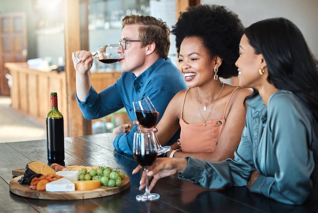 Przyjaciele z imprezy przy winie i szczęśliwa, luksusowa degustacja zdrowych organicznych owoców z serem i alkoholem na stole z jedzeniem Uśmiechnij się różnorodnością i młodą grupą ludzi w dyskusji podczas relaksującej imprezy kulinarnej