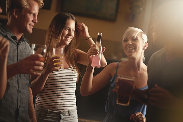 Zdjęcie przyjaciele z klubów nocnych i ludzie cheers z alkoholem koktajl i napoje dla zabawy towarzyskie zgromadzenie i toast szczęśliwy relaks i mężczyźni i kobiety z piwem razem na świętowanie weekendu i wakacji