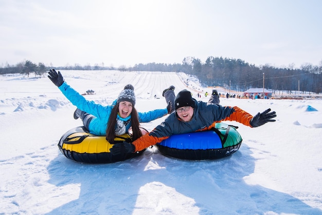 Przyjaciele zabawy. snowtubing. aktywność zimowa. jeździć ze wzgórza